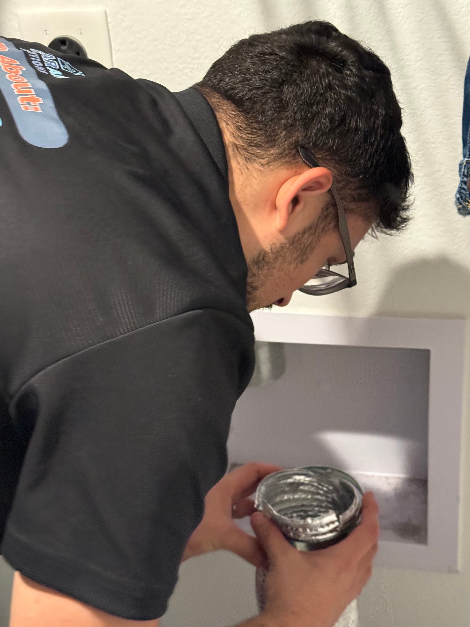 Technician inspecting dryer vent connection in Pasadena